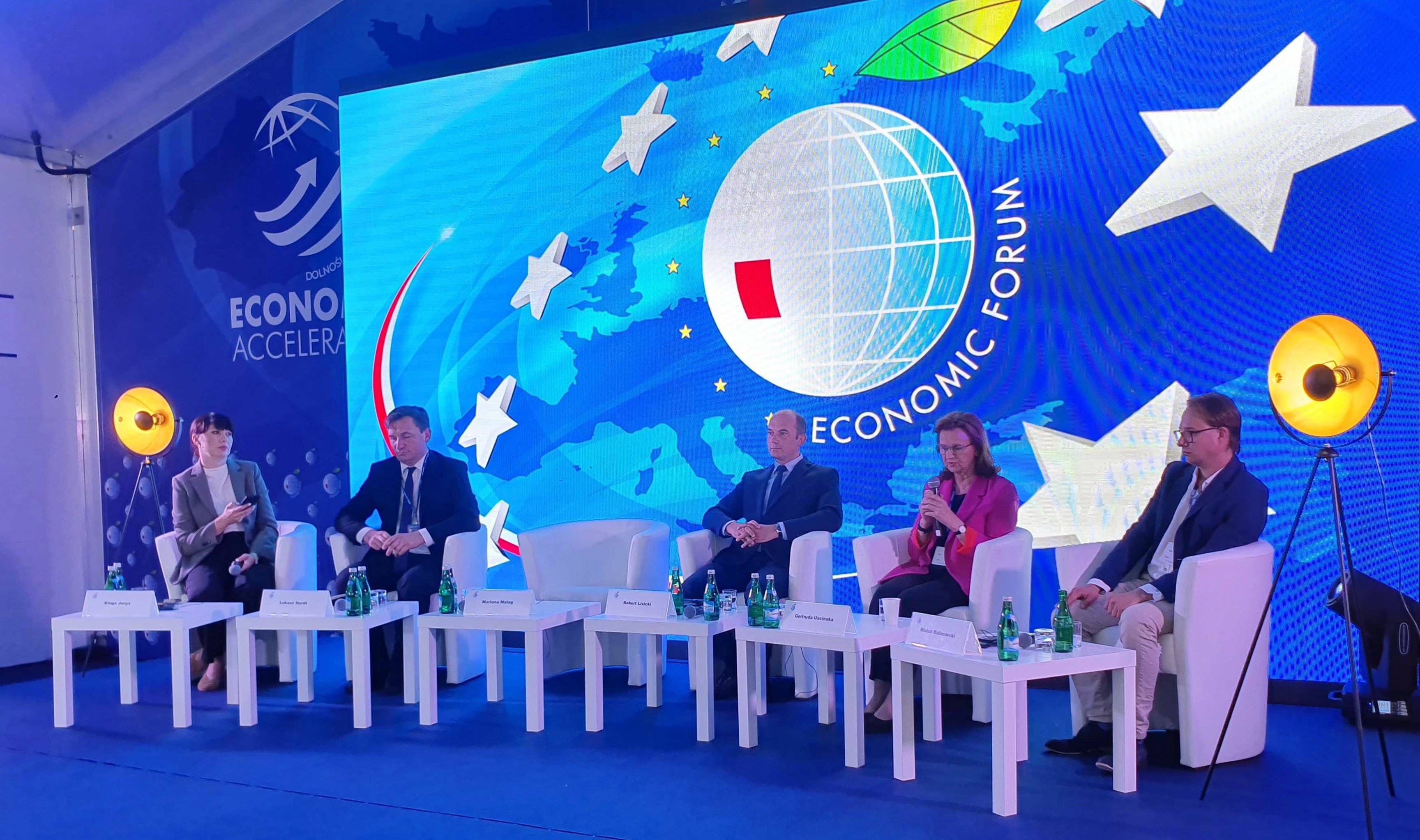 Forum Ekonomiczne w Karpaczu - prelegenci na tle niebieskiego banera. Link do powiekszonego zdjęcia
